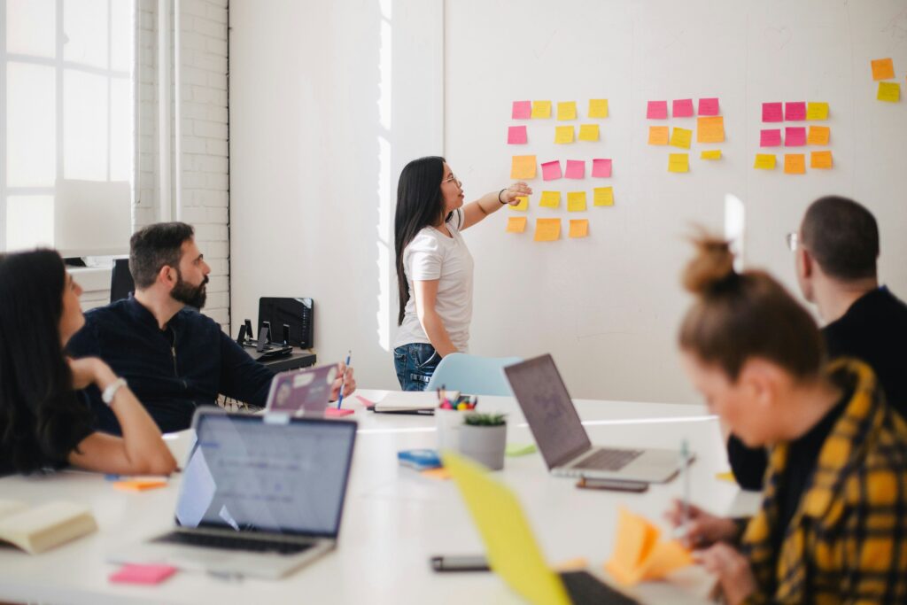 Team working together on during a brainstorming session using a whiteboard and sticky notes